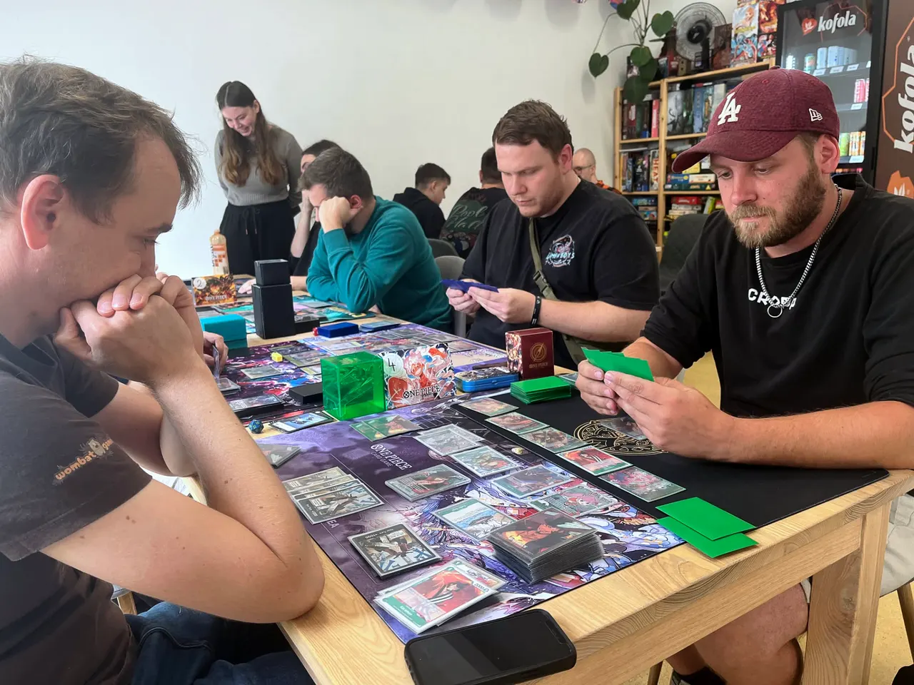 Players over their playmats mid-game at Wombat Games