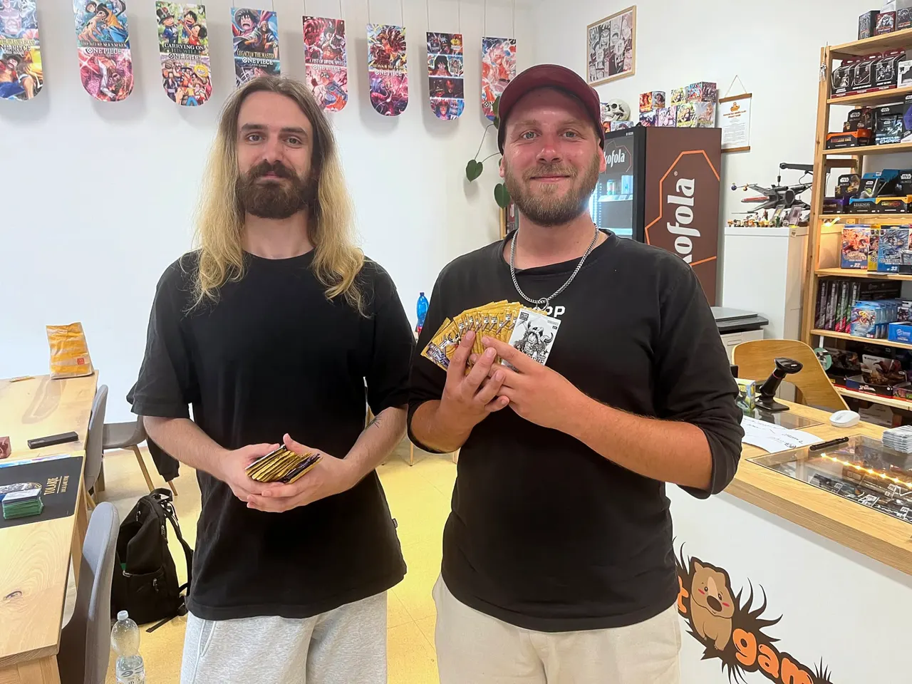 The top two players of the 6th qualifier at Wombat Games holding their cards